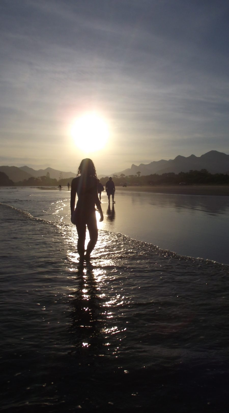 mulher sob a luz do sol da tarde na praia do guaraú